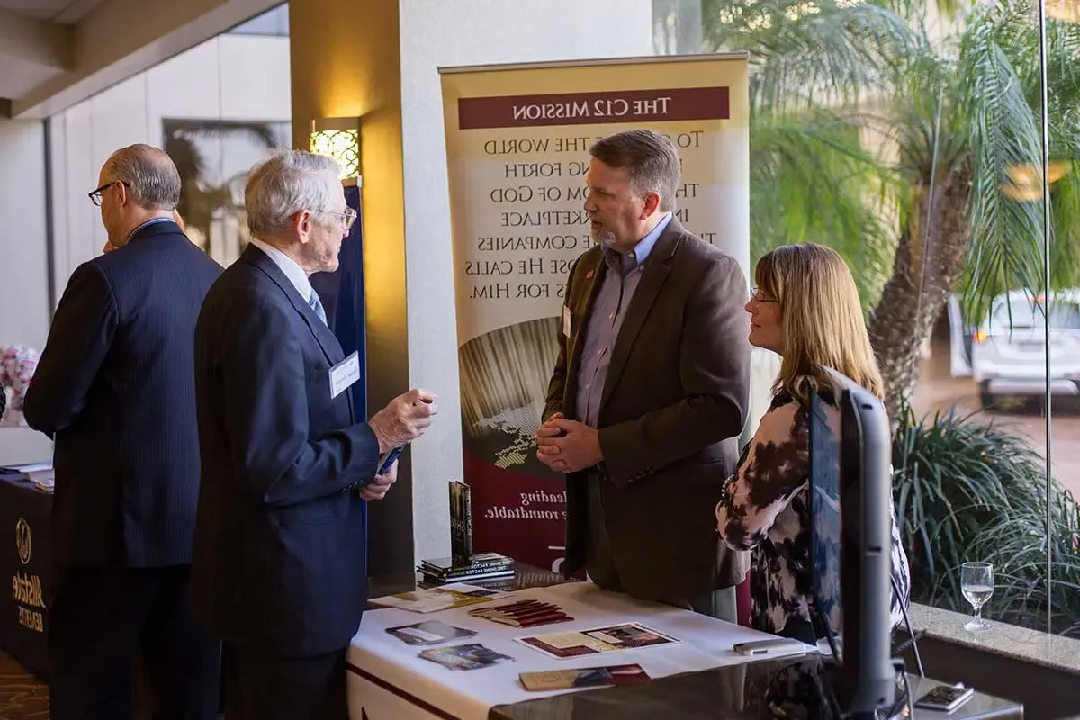 Attendees talking at one of the display tables